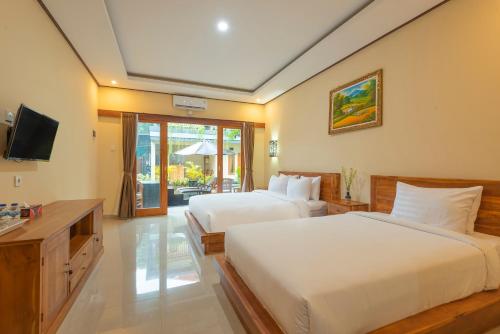 Ένα ή περισσότερα κρεβάτια σε δωμάτιο στο Liliy Guest House Legian near Beach