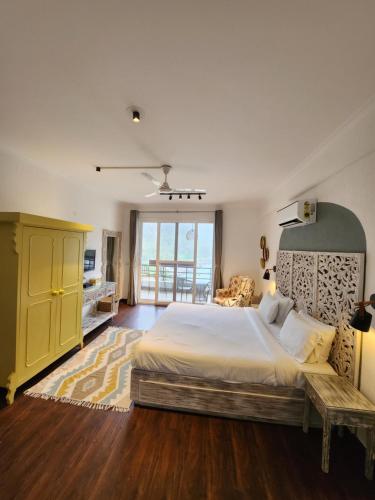 - une chambre avec un grand lit et une armoire jaune dans l'établissement Aloha on the Ganges 2BHK Ganga view Apartment by Almost Heaven, à Rishikesh