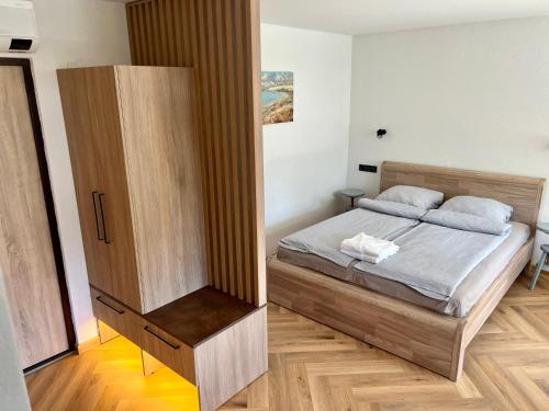 Apartamentai KOPOS Nidoje في نيدا: غرفة نوم بسرير وخزانة خشبية
