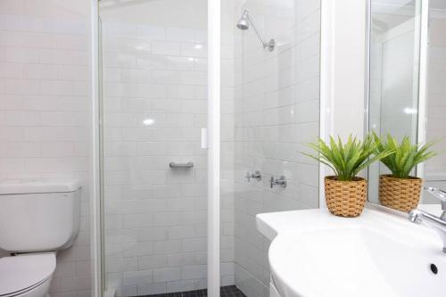 bagno bianco con servizi igienici e doccia di Darling Harbour Studio w Pool Sauna Gym Jacuzzi a Sydney
