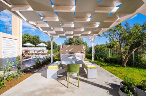 a pergola over a patio with a green chair at Meliora Suites in Drapaniás