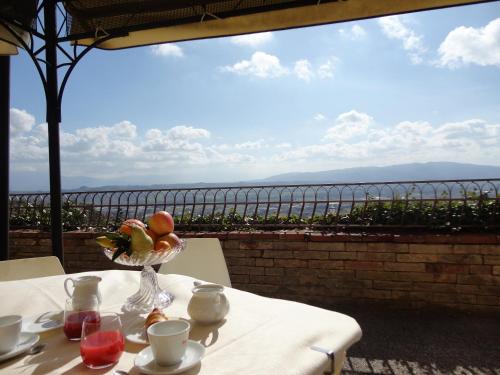a table with a bowl of fruit on it with a view at Hotel Sacro Cuore in Perugia