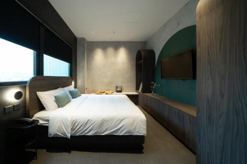 a bedroom with a bed and a flat screen tv at Hillwood House Hotel in Hong Kong