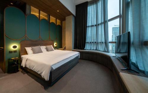 a bedroom with a bed and a flat screen tv at Hillwood House Hotel in Hong Kong