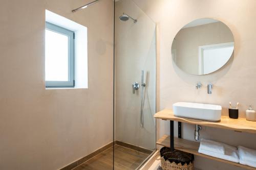 a bathroom with a shower and a sink and a mirror at Eden Kythira in Dhiakofti