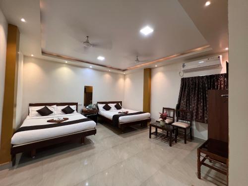 a hotel room with two beds and a television at Castle 360 Residency in Puducherry