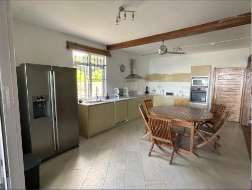 a kitchen with a wooden table and a refrigerator at 2 bedroom Apartment -Villa Ibiza in Trou d'Eau Douce