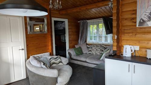 a living room with two couches in a log cabin at Snowdonia Log cabin in Trawsfynydd