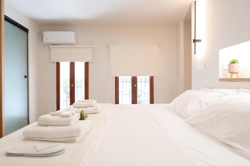 a white bedroom with white towels on a bed at Hanim Boutique Hotel in Chania Town