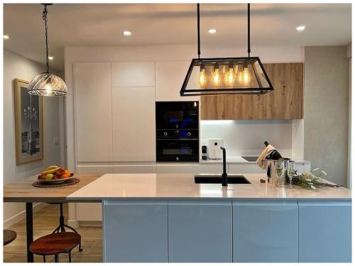 una cocina con una barra con una isla. en Elegance Lifestyle - Parking Gratuito!, en San Sebastián