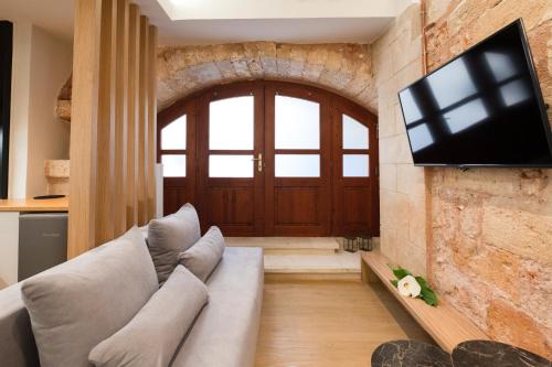 a living room with a couch and a tv on a brick wall at Hanim Boutique Hotel in Chania Town