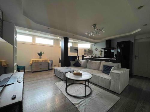 a living room with a couch and a table at Relaxed appartment in Melun
