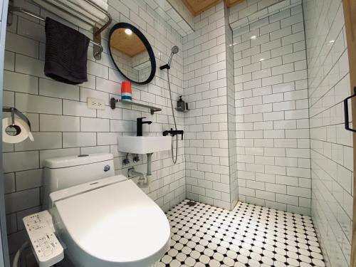 a bathroom with a white toilet and a mirror at 良文旅 Ryou Hotel Tainan in Tainan