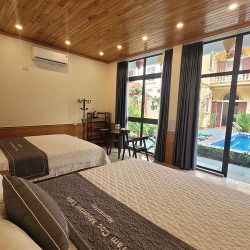 a bedroom with two beds and a view of a pool at Tam Coc Mountain Lake Homestay in Ninh Binh