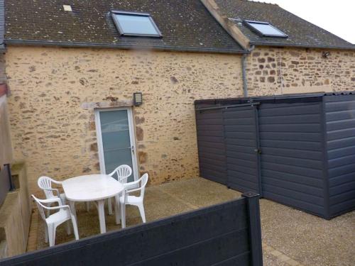 un patio avec une table et des chaises ainsi qu'un garage dans l'établissement Malouinette, à Saint-Malo
