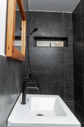 Un baño con un lavabo blanco y un espejo. en Ahomé Guest house & Lounge, en Lomé