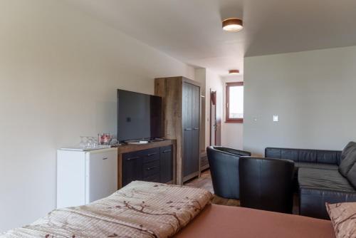 a living room with a couch and a table with chairs at Penzion U Raka in Pasohlávky
