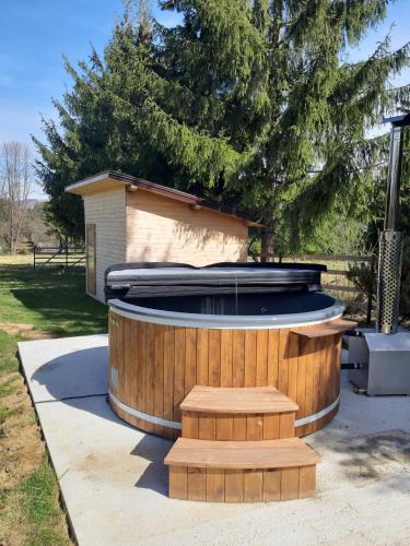 a large hot tub in a yard with a tree at Căsuța din Povești - Vatra in Vatra Dornei