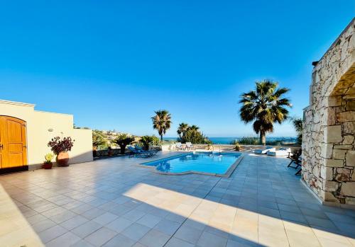 a villa with a swimming pool and the ocean at Kiki's Seaview Villa in Gerani