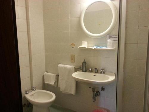 ノヴァーラにあるホテル スタッツィオーネのバスルーム(洗面台、トイレ、鏡付)