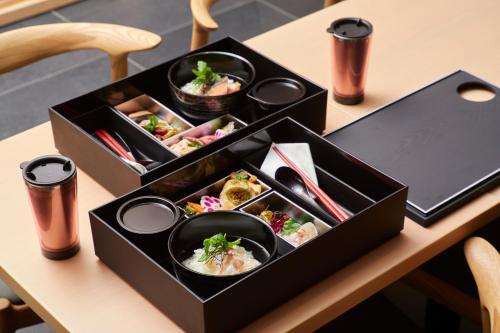 two black boxes filled with food on a table at Agora Kyoto Shijo in Kyoto