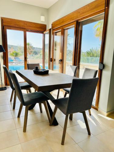 a dining room with a wooden table and chairs at Kiki's Seaview Villa in Gerani