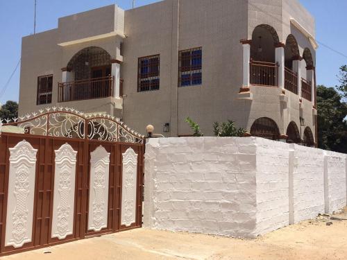 a house with a fence in front of a building at KALSA Residence in Sukuta
