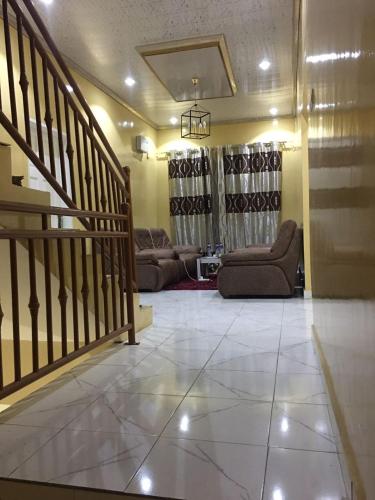 a living room with a staircase and couches in a room at KALSA Residence in Sukuta