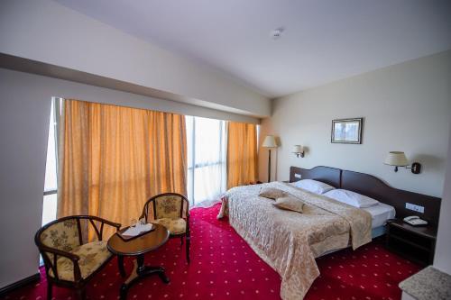 トゥルチャにあるHotel Esplanadaのベッド、テーブル、椅子が備わるホテルルームです。