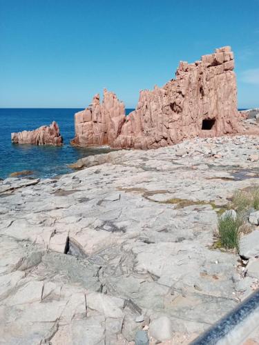 a rocky shore with rocks in the ocean at Alba Mozzafiato in Lanusei