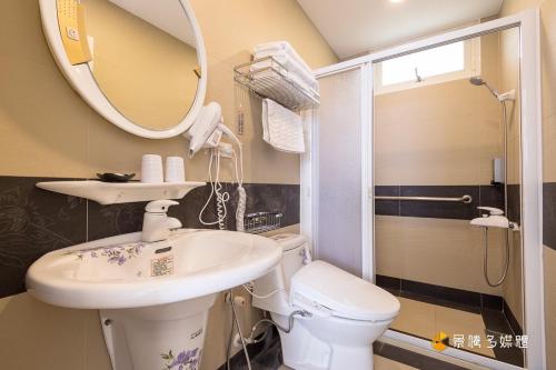 ein Badezimmer mit einem Waschbecken, einem WC und einem Spiegel in der Unterkunft Come here in Yanliau