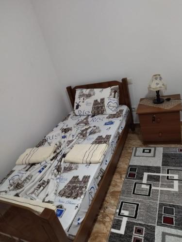 a bedroom with a bed and a night stand at The Garden Guest House in Divjakë