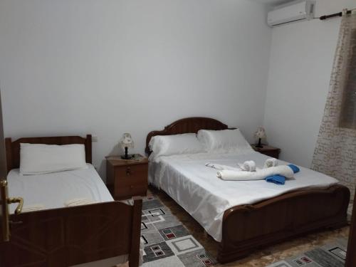 a bedroom with two beds with towels on them at The Garden Guest House in Divjakë