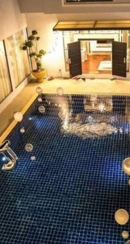 a pool with blue tiles on the floor in a room at Pandora House in Vientiane
