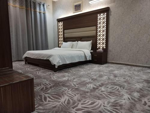 1 dormitorio con cama grande y alfombra grande en امارلس للشقق الفندقية, en Khamis Mushayt