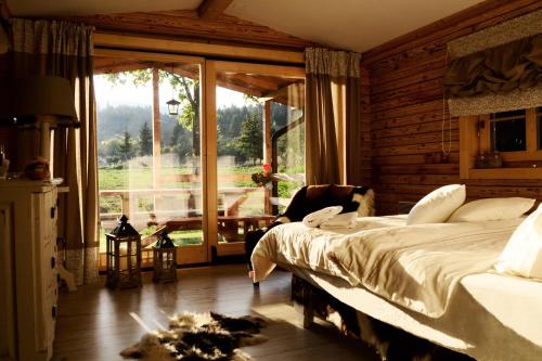 sypialnia z łóżkiem i dużym oknem w obiekcie Timian Chalet w mieście Miercurea-Ciuc