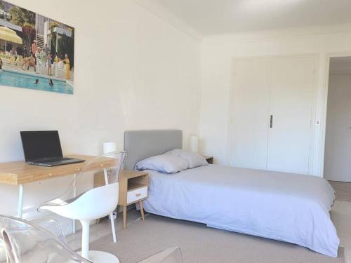 a bedroom with a bed and a desk with a laptop at La Suite de Saint-Jean-Cap-Ferrat, vue mer et accès mer in Saint-Jean-Cap-Ferrat