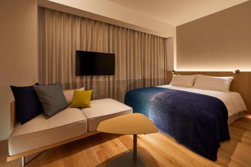 a hotel room with a bed and a couch at TSUKI Tokyo in Tokyo