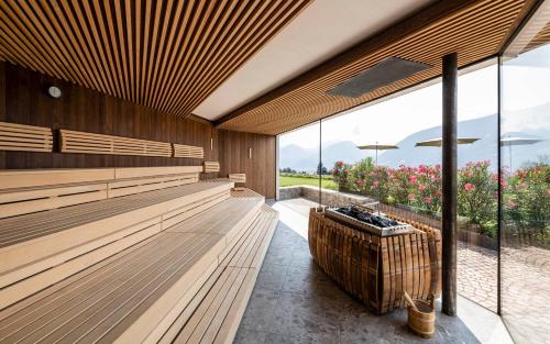 a room with wooden benches and a large window at Hotel Mitterplatt (Schenna Resort) in Schenna