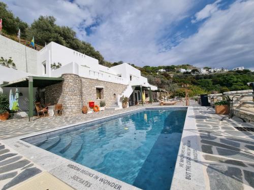 a villa with a swimming pool in front of a building at ELaiolithos Luxury Retreat Hotel & Suites - Adults Only in Khalkíon