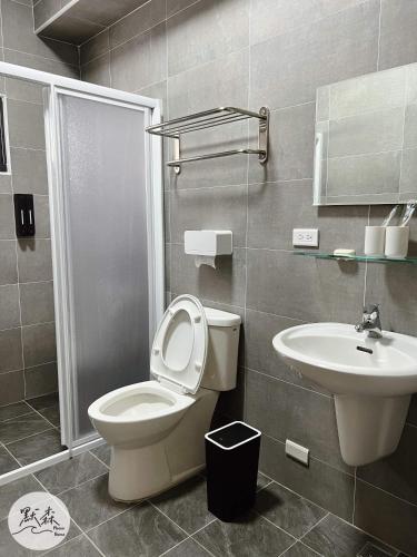 a bathroom with a toilet and a sink at 默森民宿 in Huxi