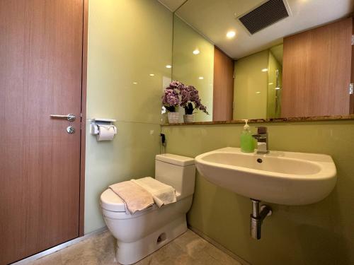 a bathroom with a sink and a toilet and a mirror at Soho Klcc Suites by Liala in Kuala Lumpur