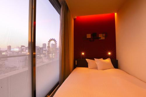 a bedroom with a bed and a large window at Agora Place Osaka Namba in Osaka