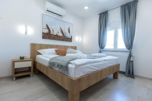 een slaapkamer met een houten bed in een kamer met een raam bij Villa Relax with sauna & jacuzzi &gym in Gornji Zemunik
