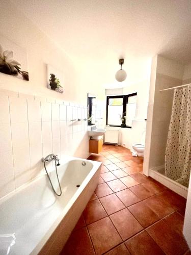 a bathroom with a tub and a toilet and a sink at FeWo Rajek -Alte Salzstraße 14- in Pogeez
