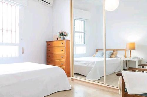 a bedroom with two beds and a large mirror at Los Duendes in Almería