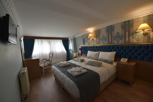 1 dormitorio con 1 cama grande y cabecero azul en İSTA Golden Palace Hotel, en Estambul