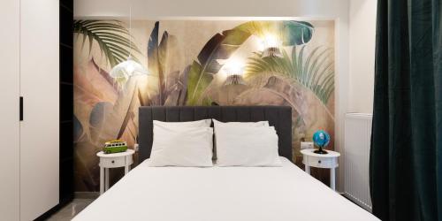 um quarto com uma cama branca e um mural em The Caravan Apartments em Tessalónica