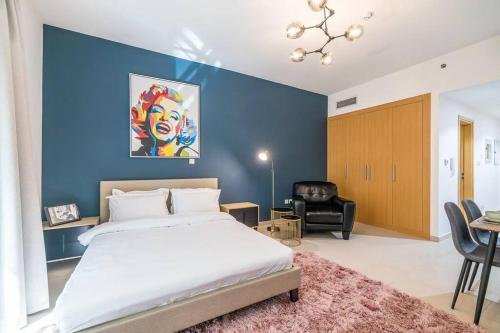 a bedroom with a large bed and a blue wall at Cozy spacious Luxury Studio in Dubai