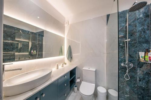 a bathroom with a sink and a toilet and a shower at Frises Corfu Town Apartment in Ágios Rókkos